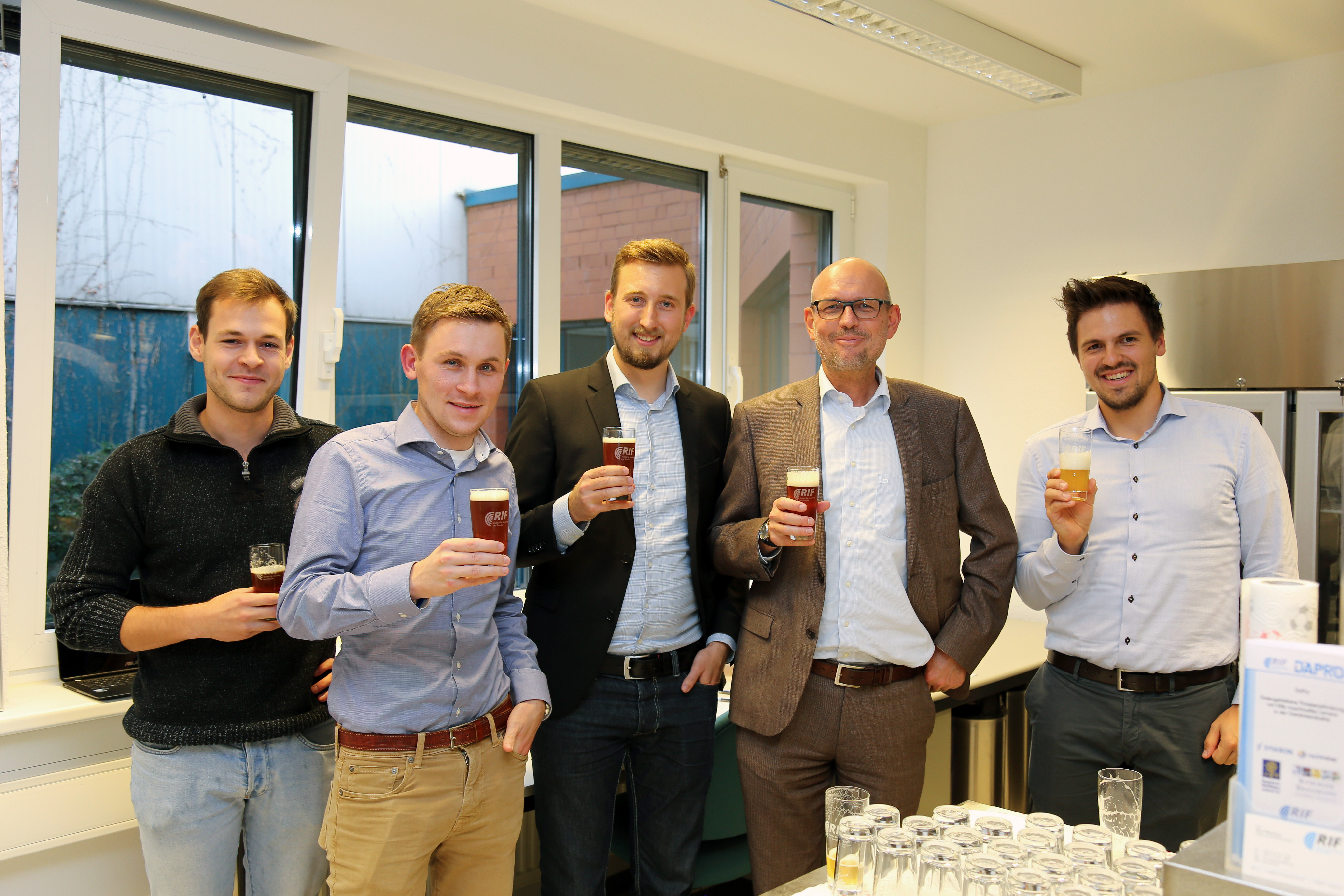 Gruppenfoto mit fünf Personen, stehend.